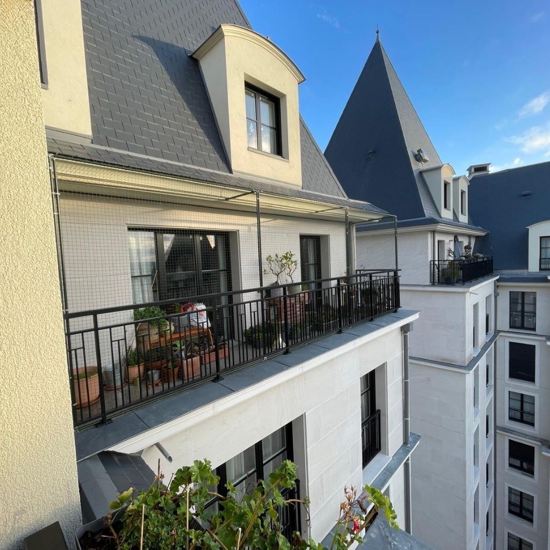 Un filet anti-pigeon installé sur un grand balcon